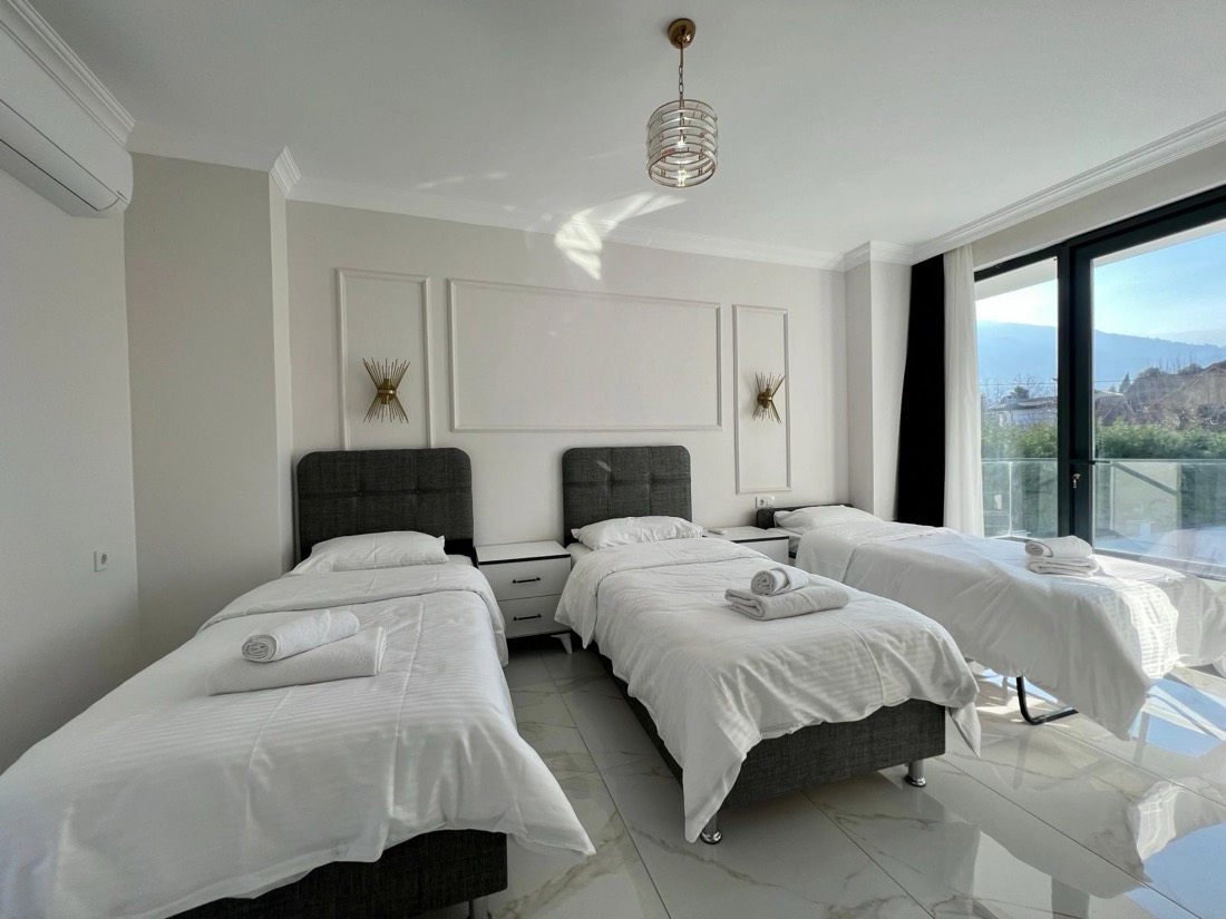 Üç tek kişilik yataklı ferah yatak odası ve balkon kapısı